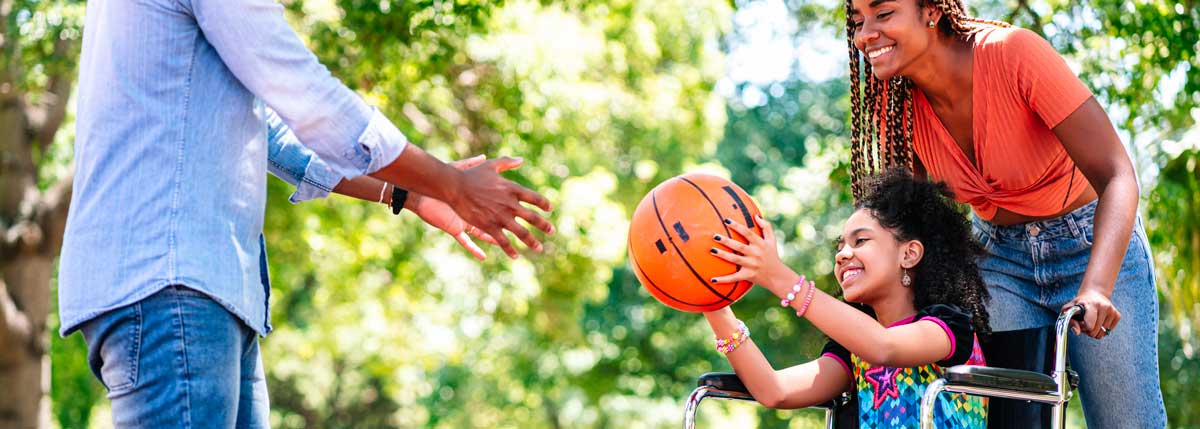 Parents qui jouent au basket avec leur fille handicapée